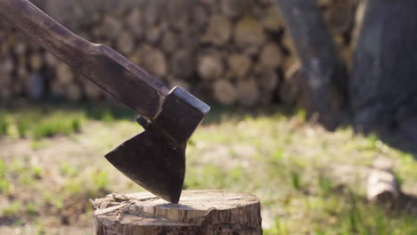 Close-up-view-of-unrecognizable-man-chopping-firewood-with-an-ax-outside-a-country-house