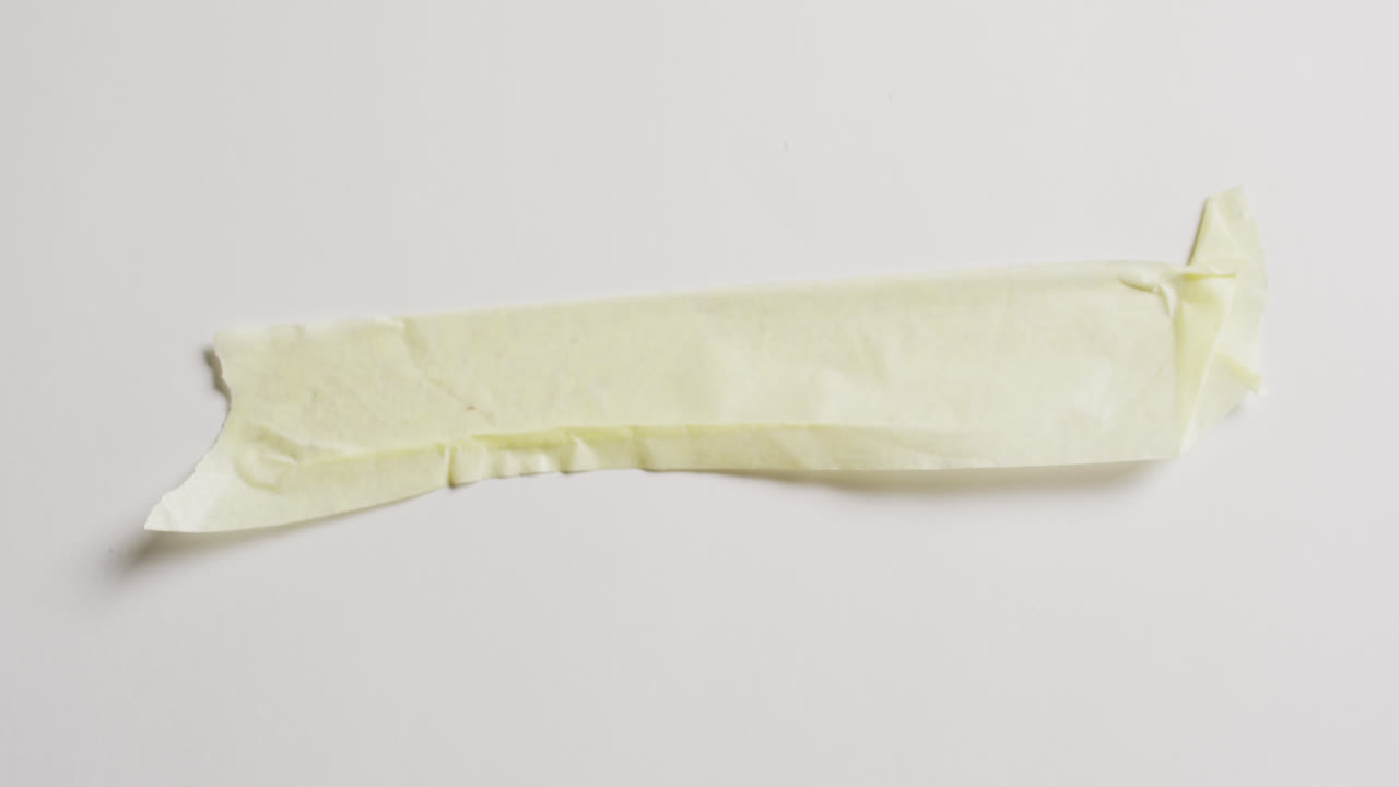 ⁇  바탕에  ⁇ 어진 노란 종이 조각의 클로즈업 비디오