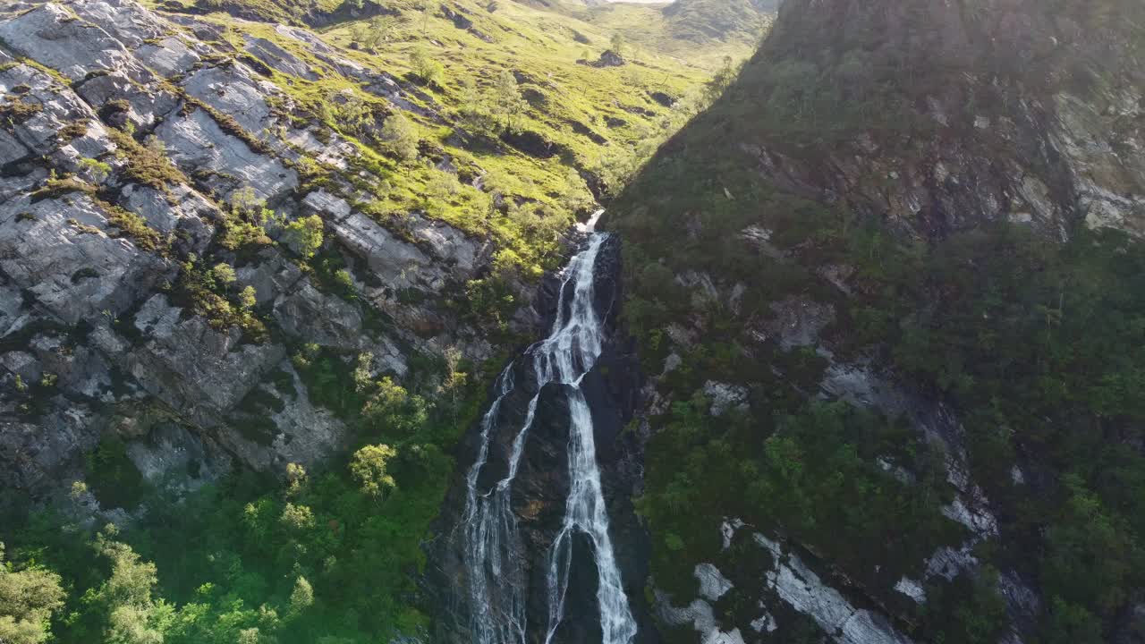 Primo piano aereo con drone della Cascata di Steall, Ben Nevis, Scozia, con acqua che cade in un lussureggiante scenario verde.