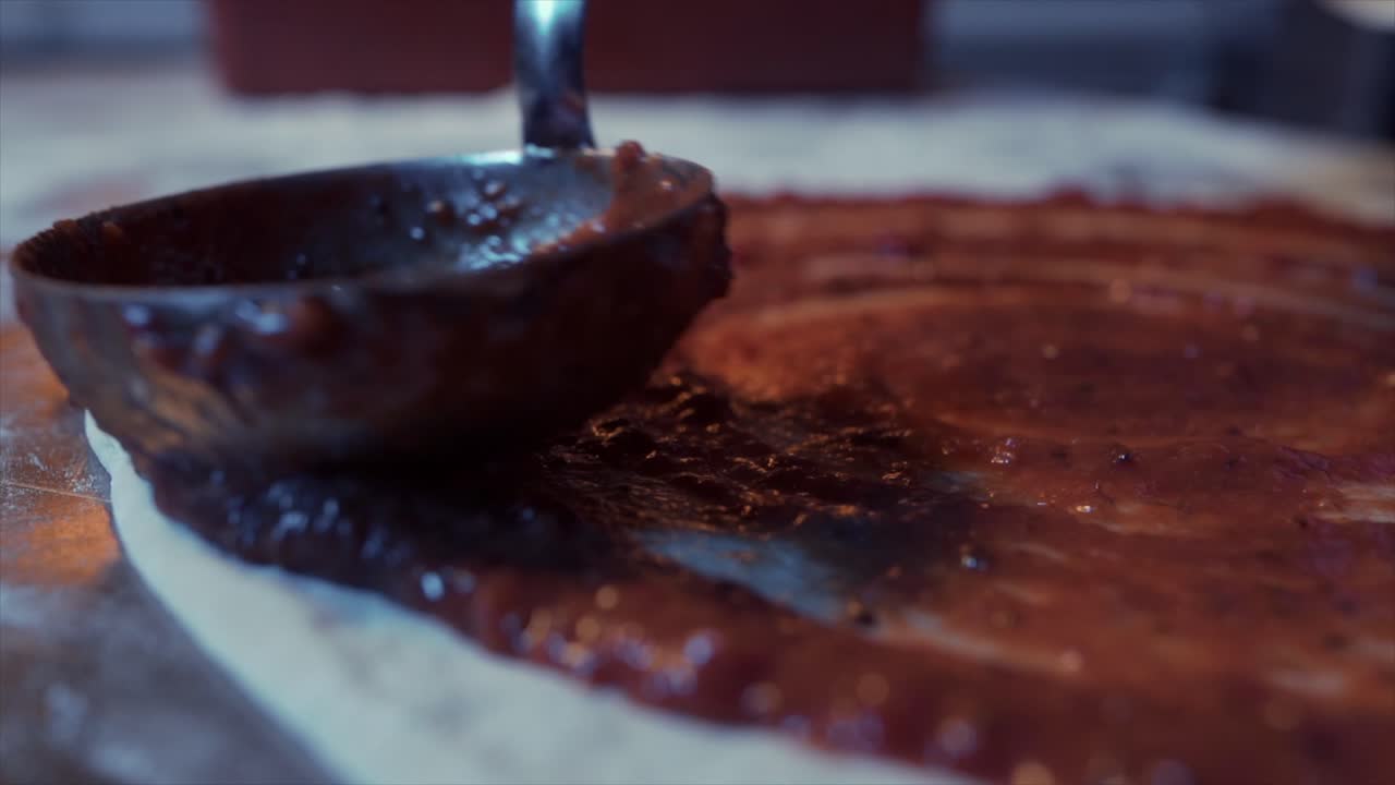 chef pone salsa de tomate en masa de pizza en pizzería 4k 120fps - material de archivo
