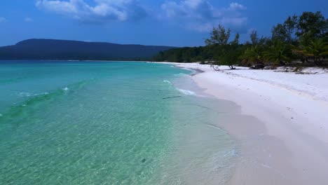 sok san beach with turquoise water washing the white sand, surrounded by palm trees and tropical vegetation. nice aerial view flight overflight flyover drone