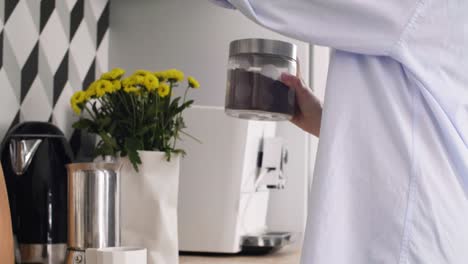 mujer alegre preparando café en su cocina