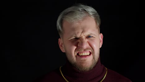 Disappointed-handsome-man-in-stylish-blouse-agressive-emotion,-shouting-at-loud-on-black-background