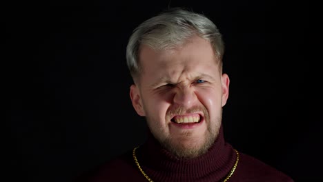 hombre guapo decepcionado en blusa elegante emoción agresiva, gritando en voz alta sobre fondo negro