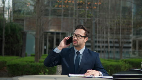 Schöner-Erfolgreicher-Geschäftsmann,-Der-Im-Stadtpark-Vor-Dem-Büro-Sitzt,-Mit-Dem-Handy-Telefoniert-Und-An-Dokumenten-Arbeitet,-Notizen-Macht,-Glücklicher-Mann,-Der-Im-Sonnenlicht-Im-Freien-Mit-Dem-Handy-Plaudert