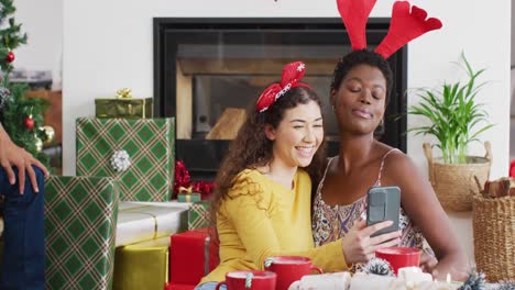 Happy-diverse-female-friends-using-smartphone,-taking-selfies
