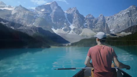 man boating in a lake and a view of the mountain