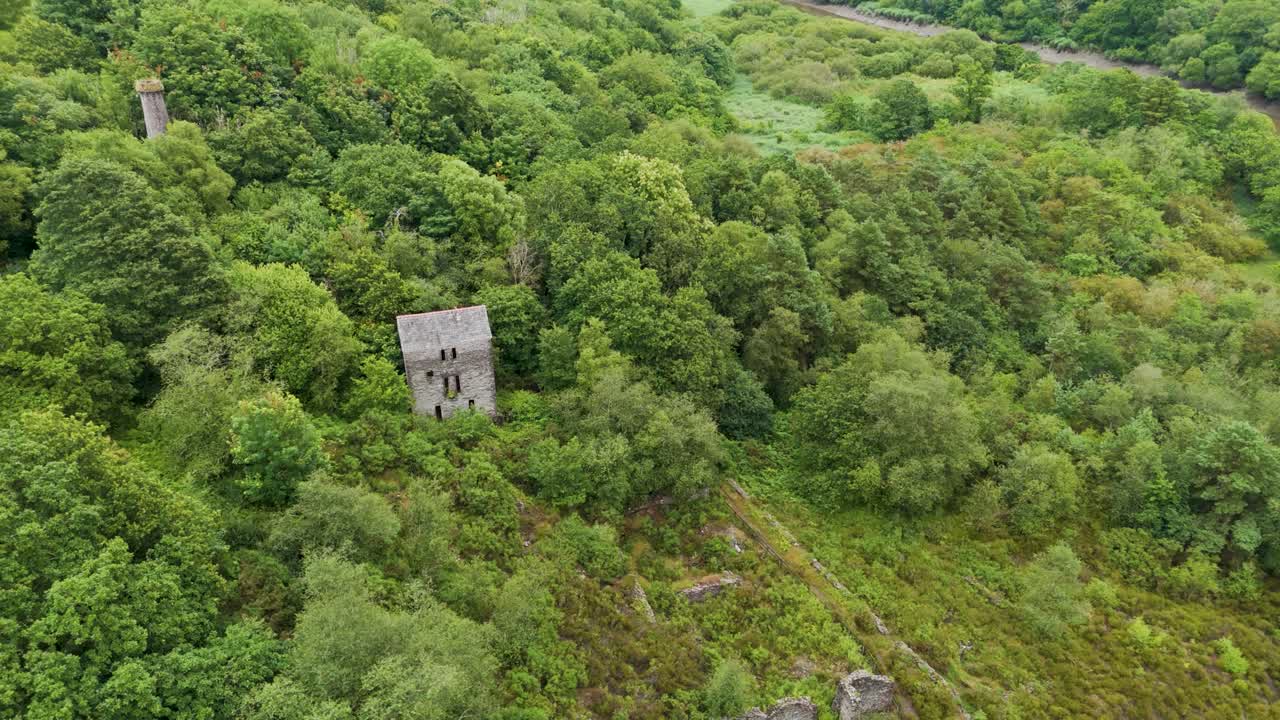 Veduta aerea ascendente di antiche miniere di stagno e rame lungo le rive del fiume Tamar in Cornovaglia, che evidenzia rovine industriali storiche