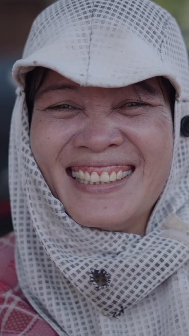A smiling woman wearing a headscarf