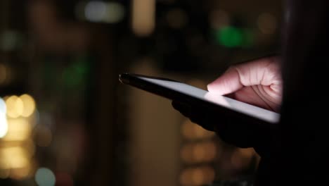 persona que usa un teléfono inteligente por la noche en una ciudad