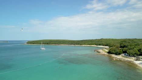 Drone-footage-on-a-beach-in-Croatia-with-seagulls-flying,-around,-sea,-turquoise-blue