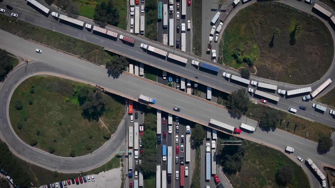 Tampilan drone udara statis dari atas ke bawah yang menunjukkan pergerakan kendaraan dan arus lalu lintas di Jalan Raya Meksiko–Querétaro di pintu keluar Mexico City, menyoroti pola transportasi dan infrastruktur
