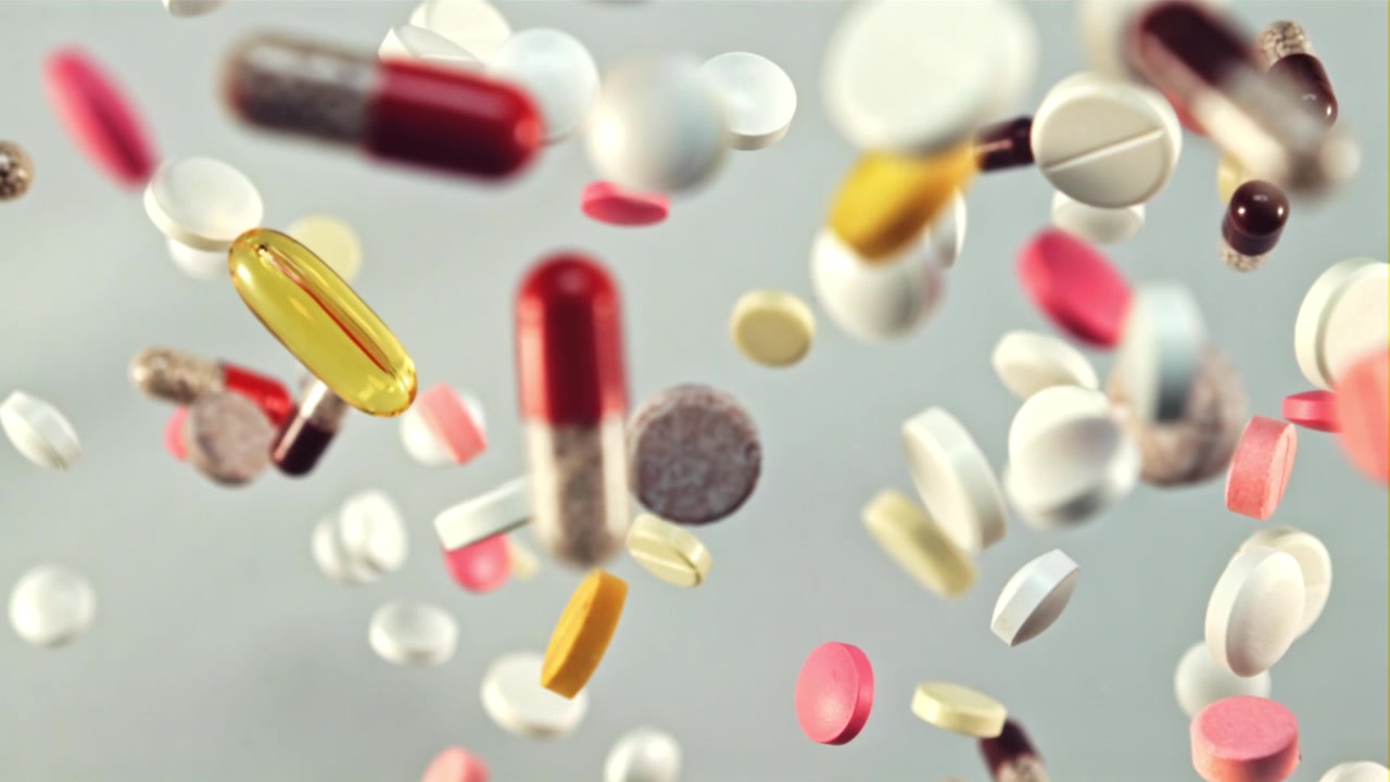 Colorful Medicine Pills and Capsules Falling in Slow Motion