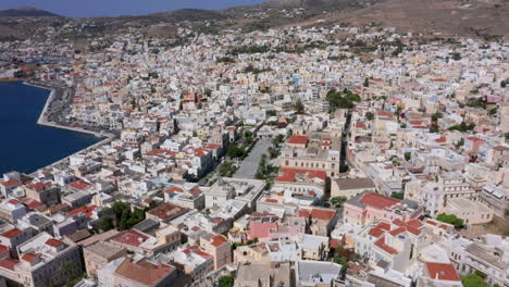 Aerial:-Slow-panoramic-drone-shot-of-Miaouli-square-in-Ermoupoli-of-Syros-island,-Greece-on-a-sunny-day