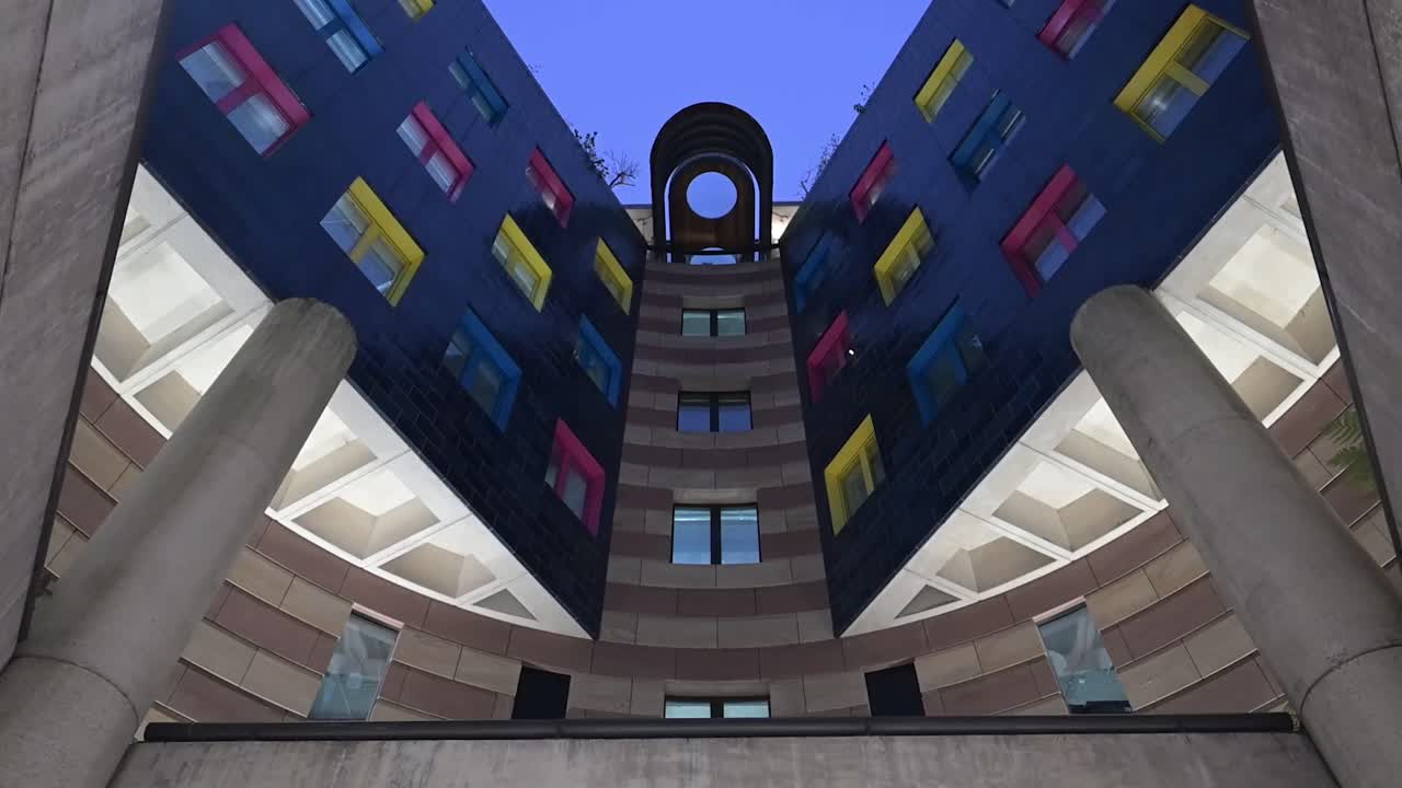 Vista interna del Number One Poultry nella City di Londra di sera, che mette in risalto le linee di design moderno e la calda illuminazione architettonica