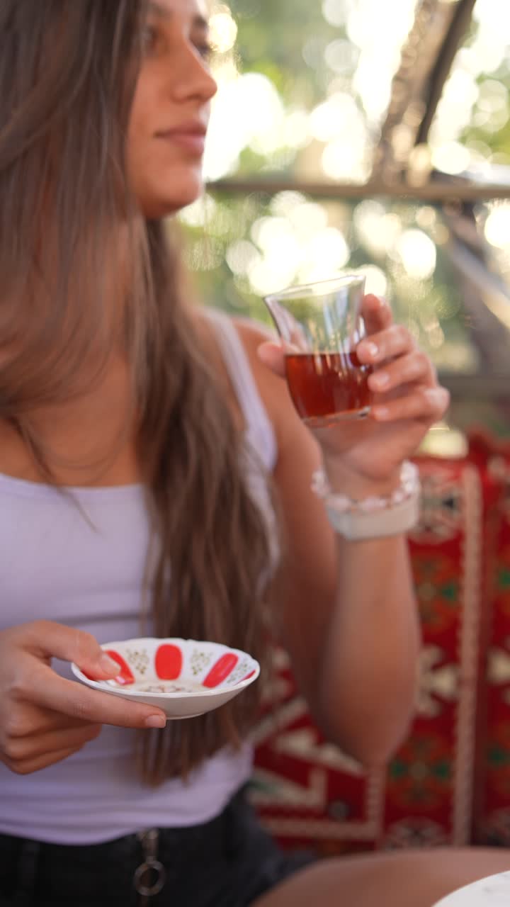 mujer disfrutando de una taza de té turco al aire libre