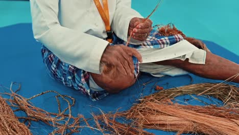 an arab fisherman making rope using his hand with palm fibres