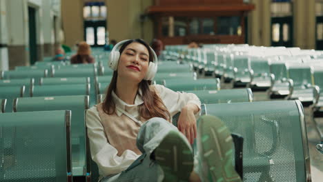 woman listening to music in a train station