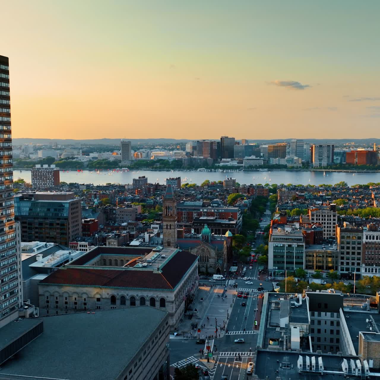 Flying between two beautiful tower blocks and opening view on the Charles River in Boston. Panorama of the city from top at sunset