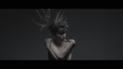 a woman dressed as mother nature moves slowly in a dance-like motion
