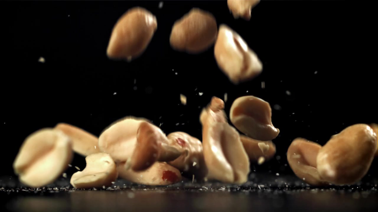 Slow Motion Peanuts Falling and Bouncing on Black Background