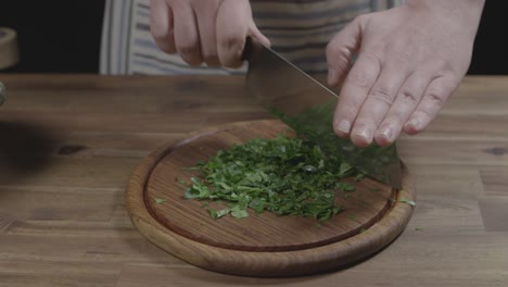 proceso de cortar perejil para la salsa chimichurri argentina, el chef utiliza un cuchillo de hacha de cocina