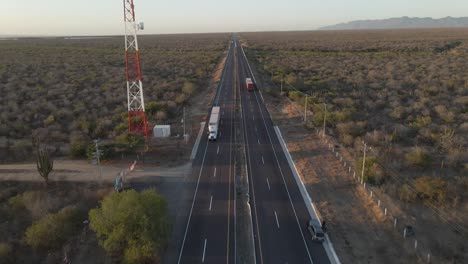 camiones conduciendo en direcciones opuestas en una carretera vacía del desierto, vista aérea