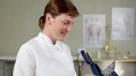 female physiotherapist using digital tablet