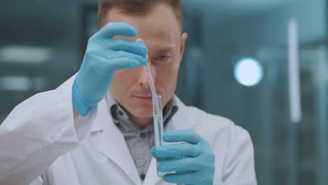 department of quality control in chemical laboratory in industrial factory man and woman are exploring samples of products using test tubes and microscope