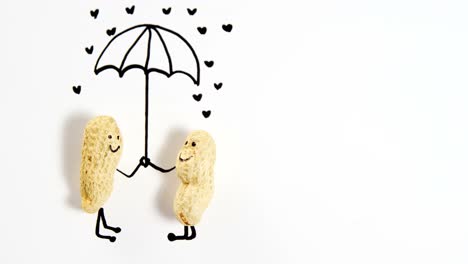 estatuilla de maní como una pareja de pie bajo un paraguas