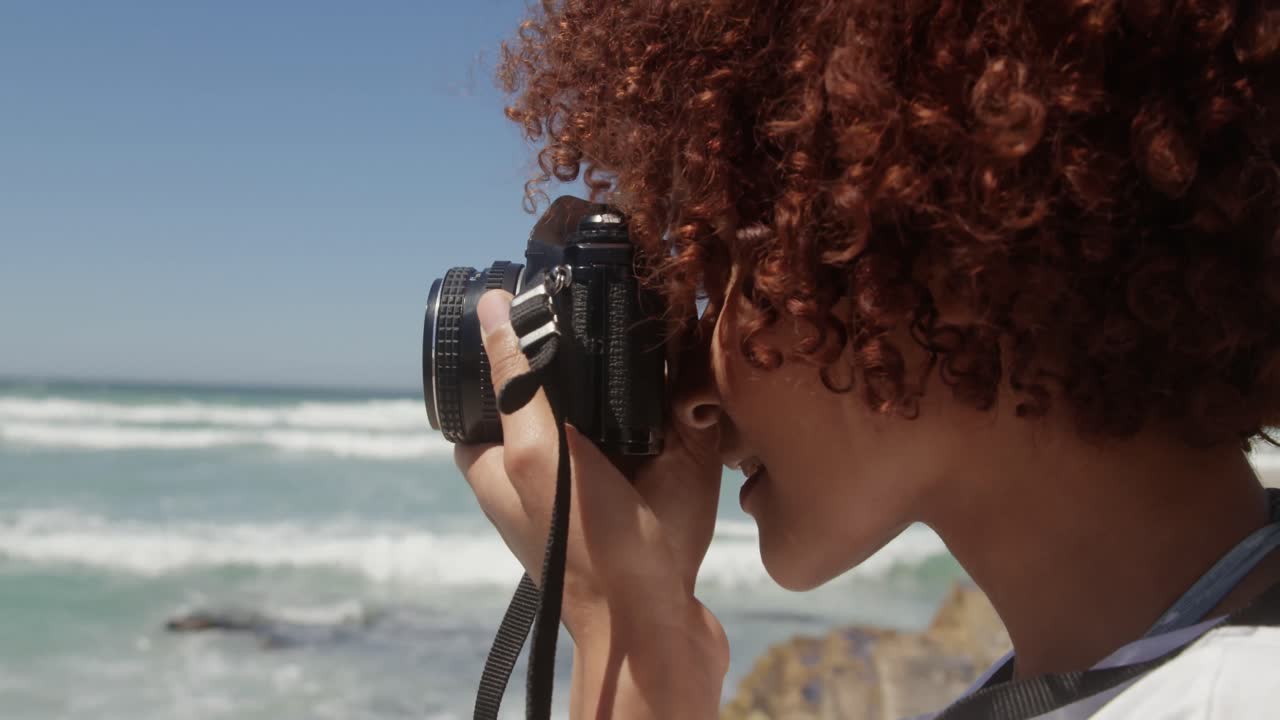 Femme prenant une photo avec un appareil photo numérique sur la plage 4k