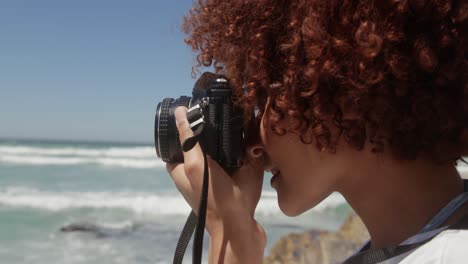 woman taking photo with digital camera on the beach 4k