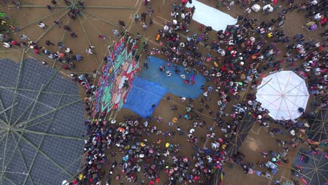 Big-colourful-kite-with-lot-of-people-around-at-Sumpango-Guatemala,-aerial