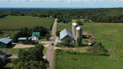 vista aérea siguiendo a un automóvil que pasa por una granja en el norte del estado de nueva york