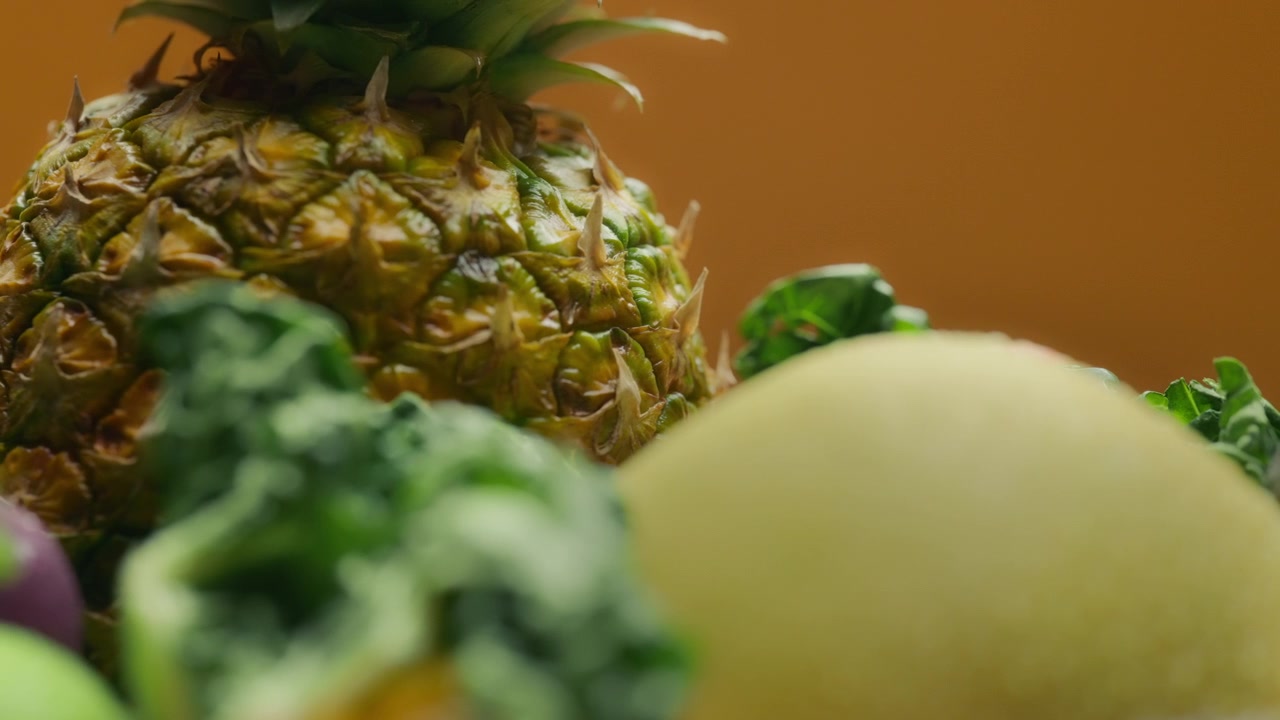 Fresh pineapple against fruits and vegetables background