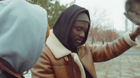 two african american men checking under car hood and speaking