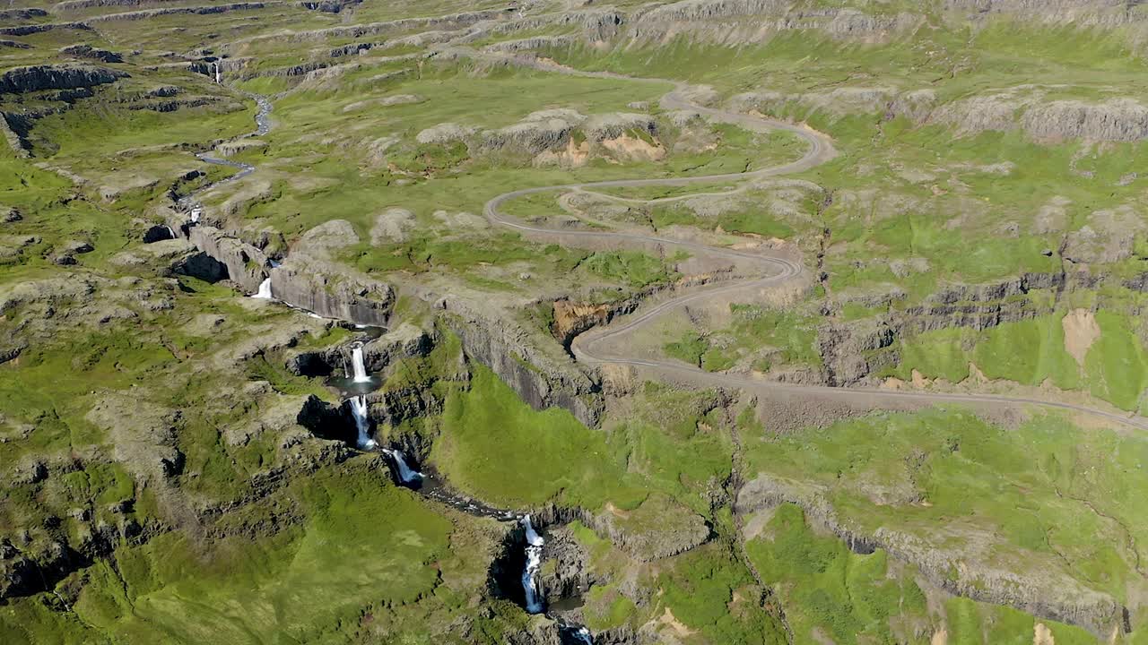 Gorgeous aerial panorama, drone overlooking Klifbrekkufossar and adjacent rocky and mossy plateau. Beautiful high Icelandic waterfall.