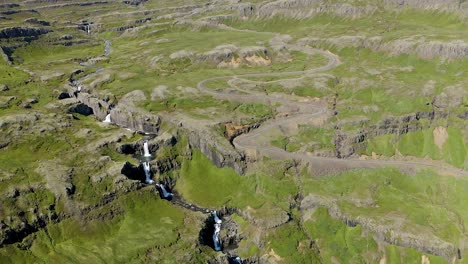 gorgeous aerial panorama, drone overlooking klifbrekkufossar and adjacent rocky and mossy plateau. beautiful high icelandic waterfall.