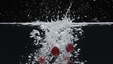 video de uvas cayendo en el agua con espacio de copia en fondo negro