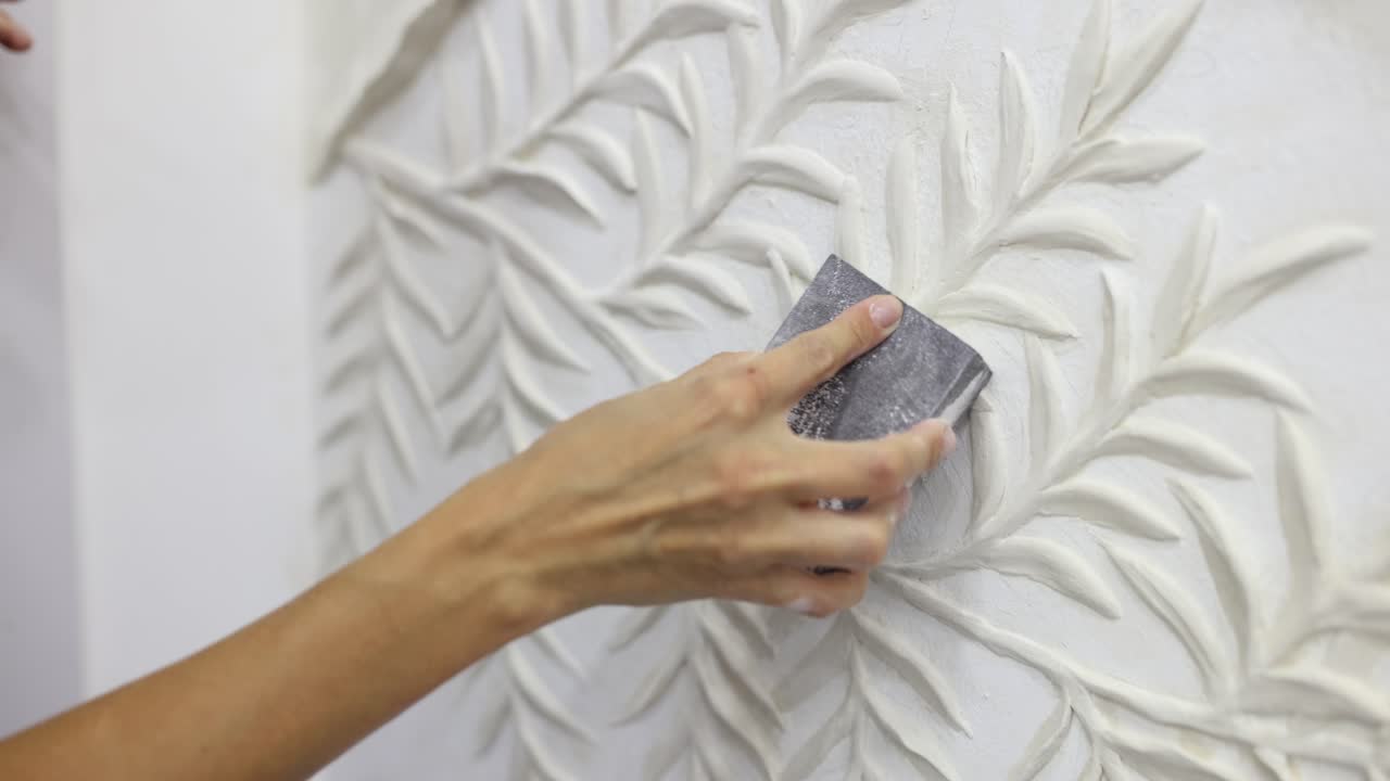 Sanding a plaster wall decoration