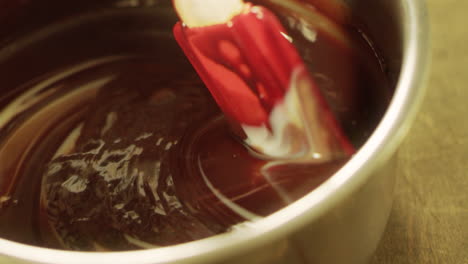 Closeup-liquid-chocolate-mixing-with-spatula-in-slow-motion.