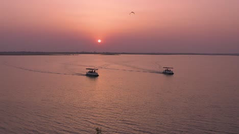 tourist taking boat safari at huge lake at sunset