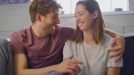 Excited-Couple-With-Woman-With-Prosthetic-Arm-Sitting-On-Bathroom-Floor-With-Positive-Pregnancy-Test