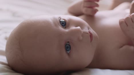 Closeup-of-newborn-baby-lying-on-bed-and-looking-away