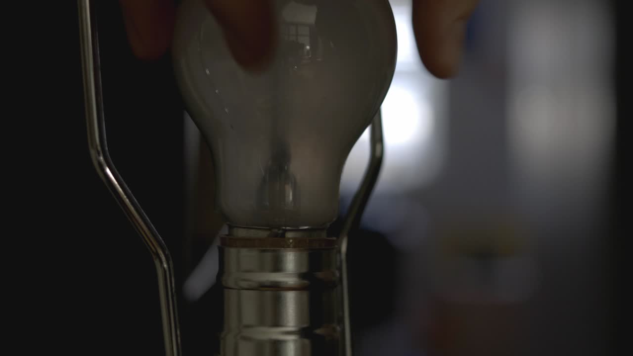 Installing A Light Bulb Into A Socket And Lighting It - closeup shot