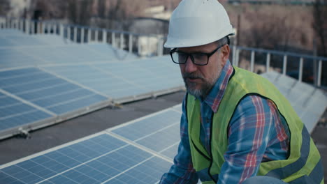 solar panel technician inspecting rooftop installation