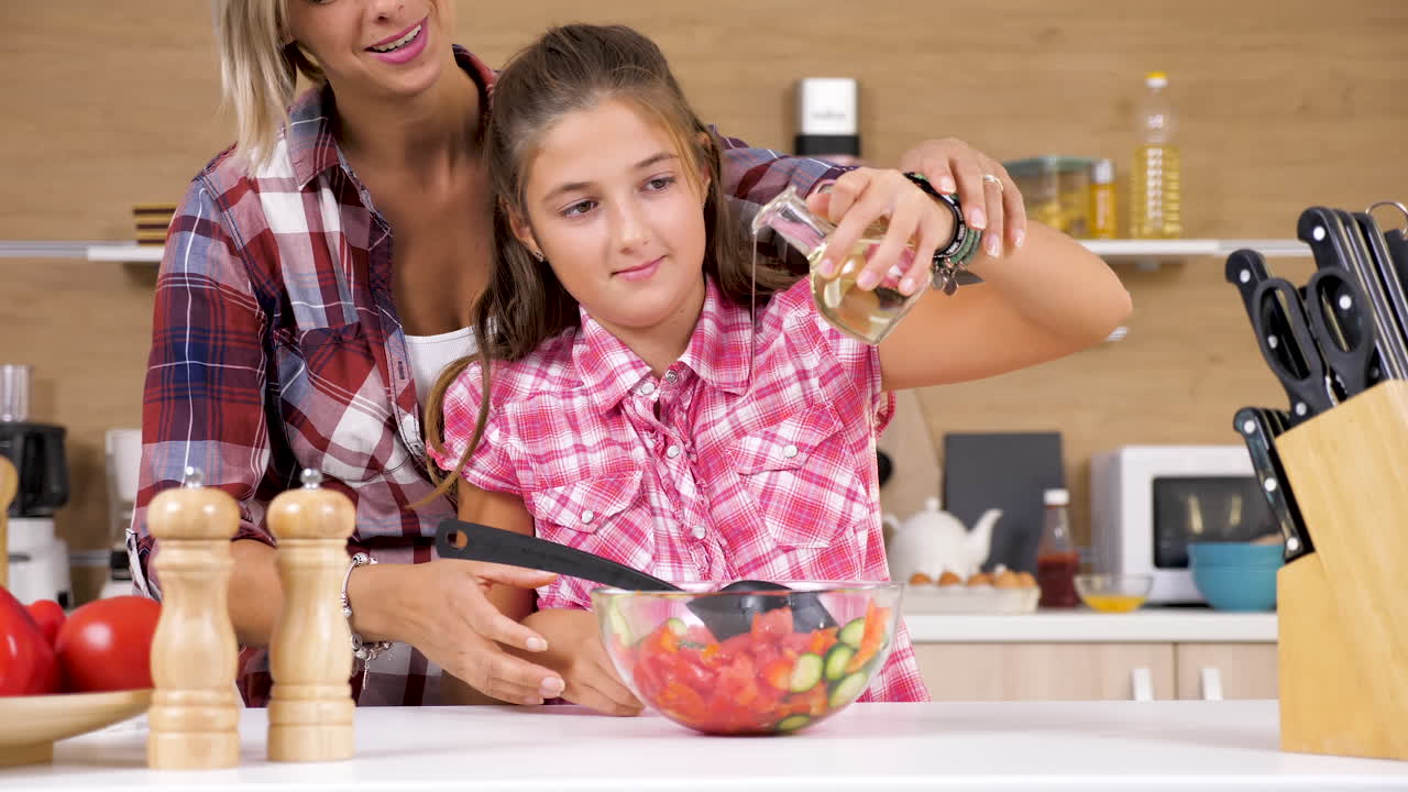 Mother and Daughter Making Salad Together in Kitchen