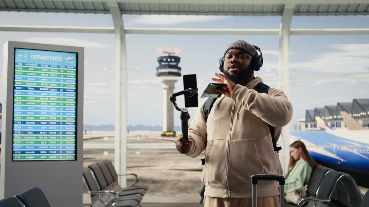 Uomo afroamericano che fa vlogging sui viaggi nella sala partenze dell'aeroporto