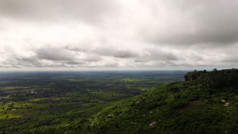 Phnom-Kulen,-Kambodschas-üppige-Grüne-Landschaft,-Fliegt-Hoch-über-Den-Hügel-Und-Enthüllt-Reisfelder-Mit-Bewölkter-Skyline-Während-Der-Regenzeit