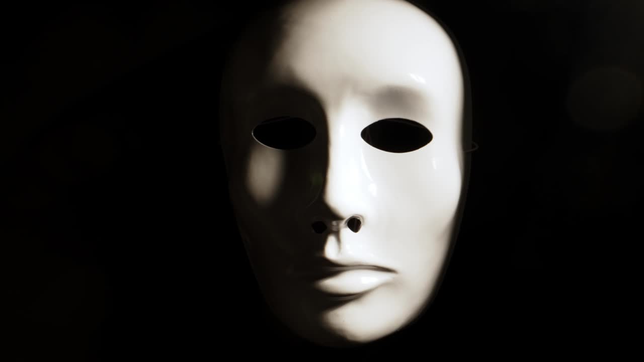White face mask on dark background.